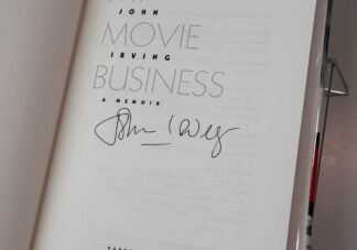 Various pictures of the John Irving memoir My Movie Business signed on the title page by the author.