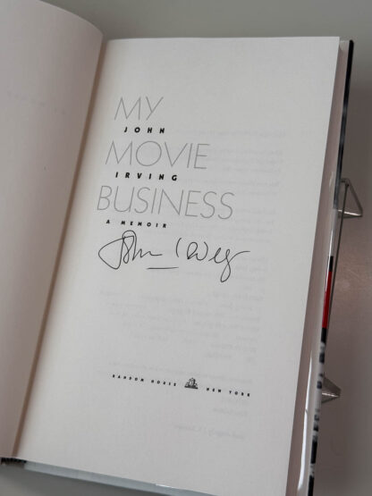 Various pictures of the John Irving memoir My Movie Business signed on the title page by the author.