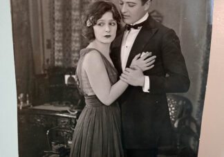 A picture of a promotional photo for the silent film "A Woman Gives" starring Norma Talmadge.